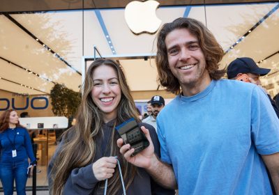 苹果零售店内顾客手持 iPhone Duo 折叠手机合影
