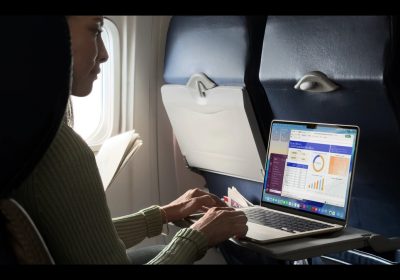 一名用户在飞机座位上使用 MacBook Air 处理表格与文档的工作场景实拍