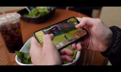 玩家手持 iPhone 游玩《堡垒之夜》的实拍场景