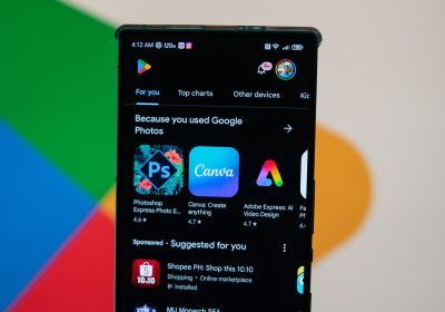 谷歌四色标志背景前的手机正打开 Google Play 应用商店