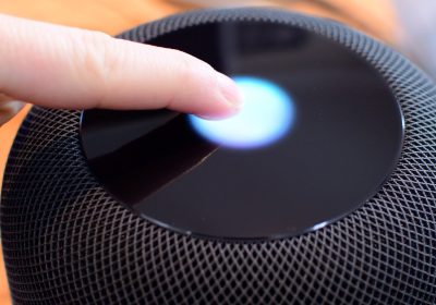 手指轻点 HomePod 顶部触控面，屏幕泛起蓝光