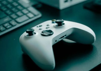 Xbox白色无线手柄放在桌面键盘旁的产品照