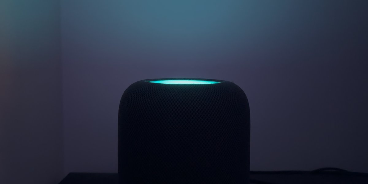 暗室中 HomePod 顶部发出青色光晕的实拍