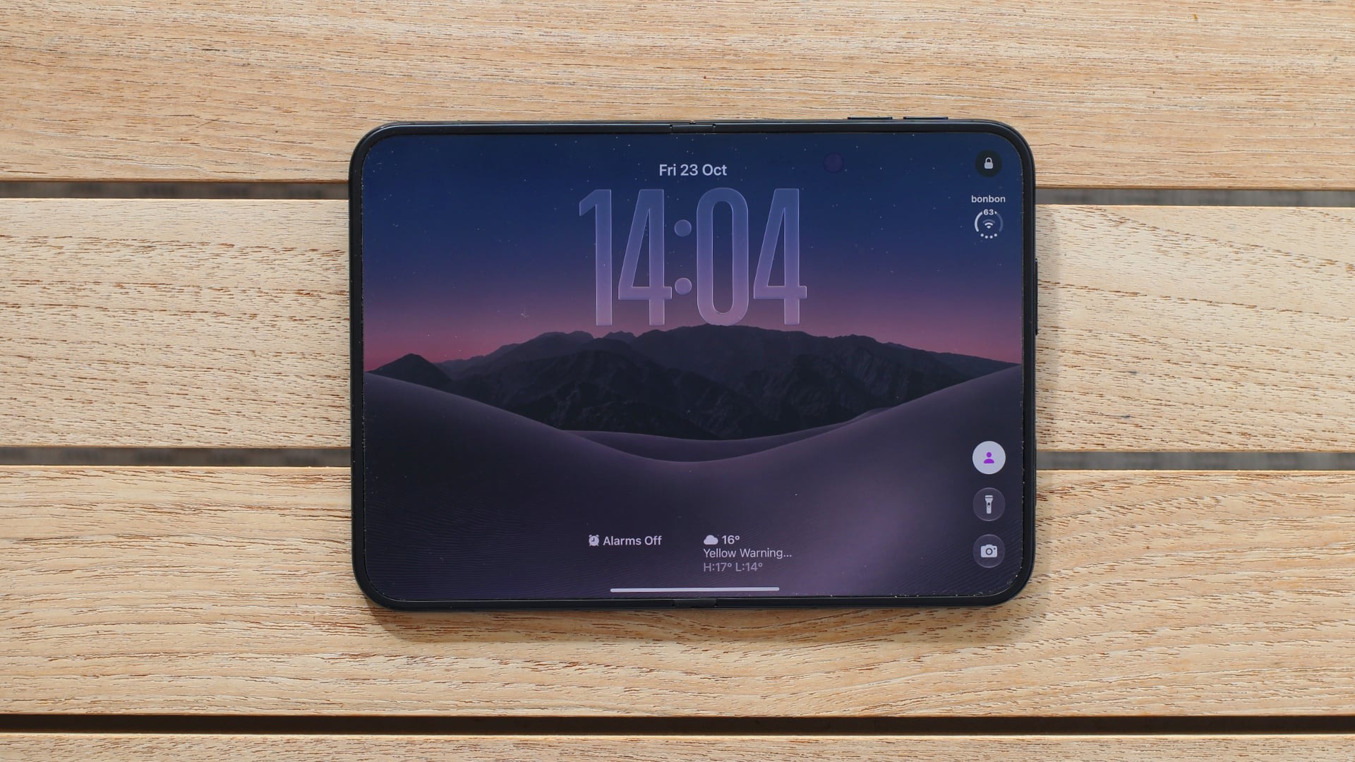 iPhone Duo 折叠平放在木桌上显示外屏时钟