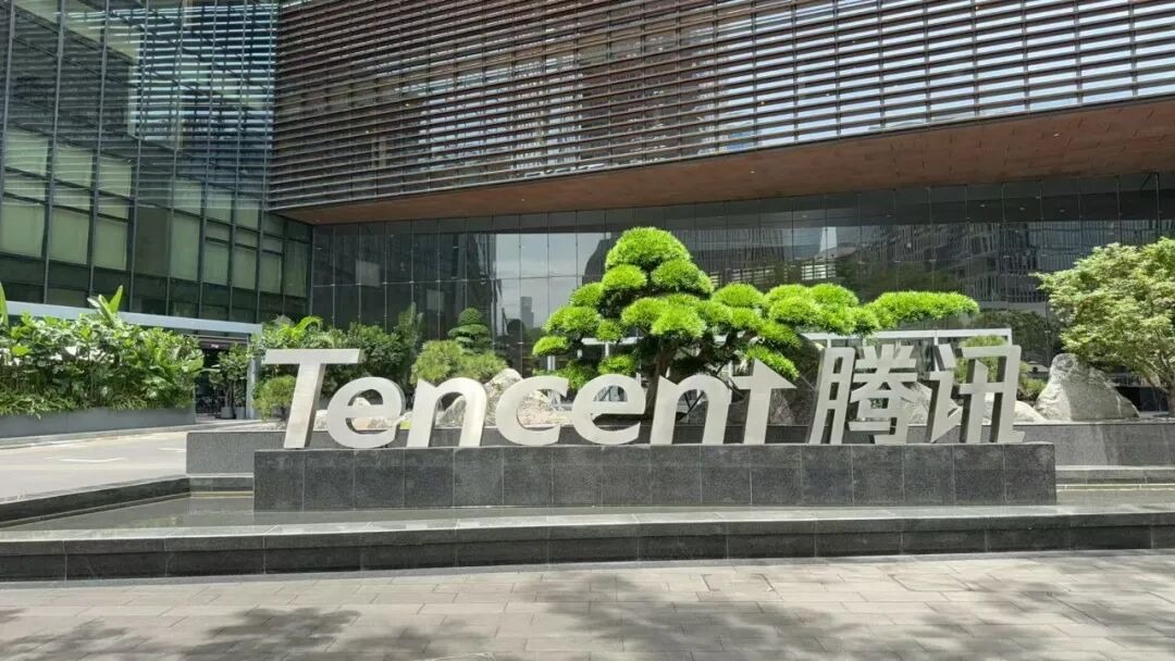 腾讯总部园区实景,Tencent 腾讯标志立于楼前绿植之间