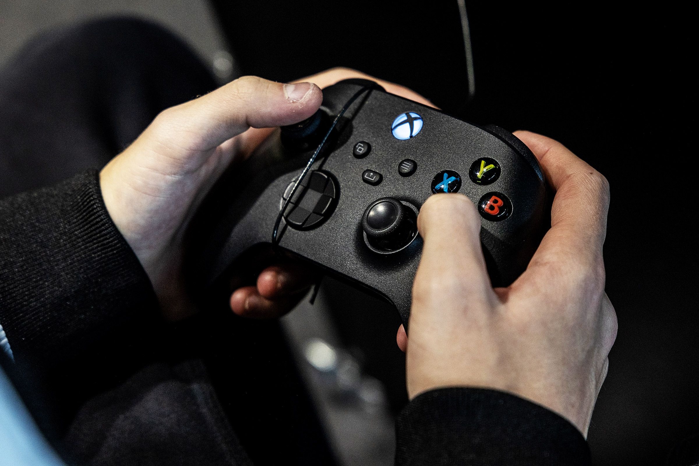 双手握持黑色 Xbox 手柄特写实拍